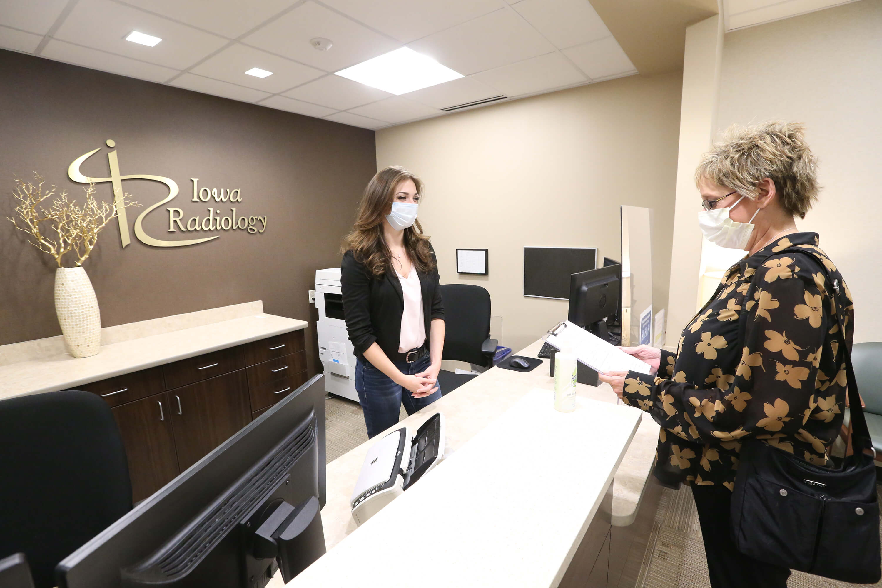 Patient Information women-talking-to-front-desk-receptionist